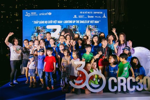 A group of people standing in front of a crowd posing for the camera    Description automatically generated